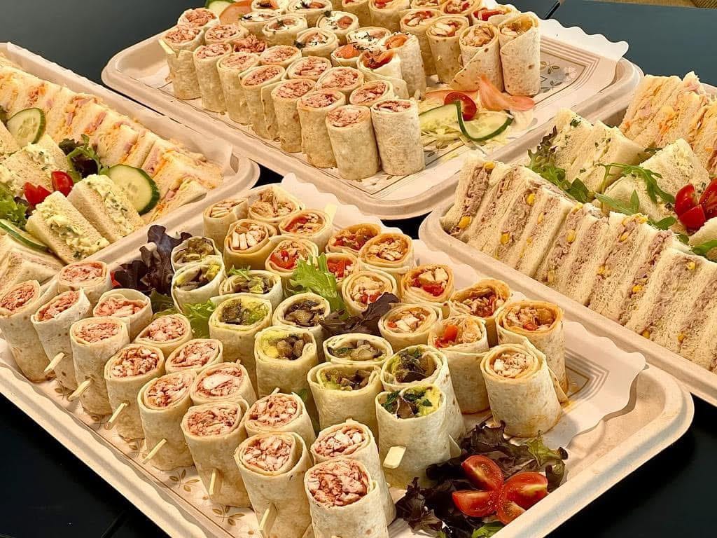 Platters of finger sandwiches and tortilla wraps arranged for catering