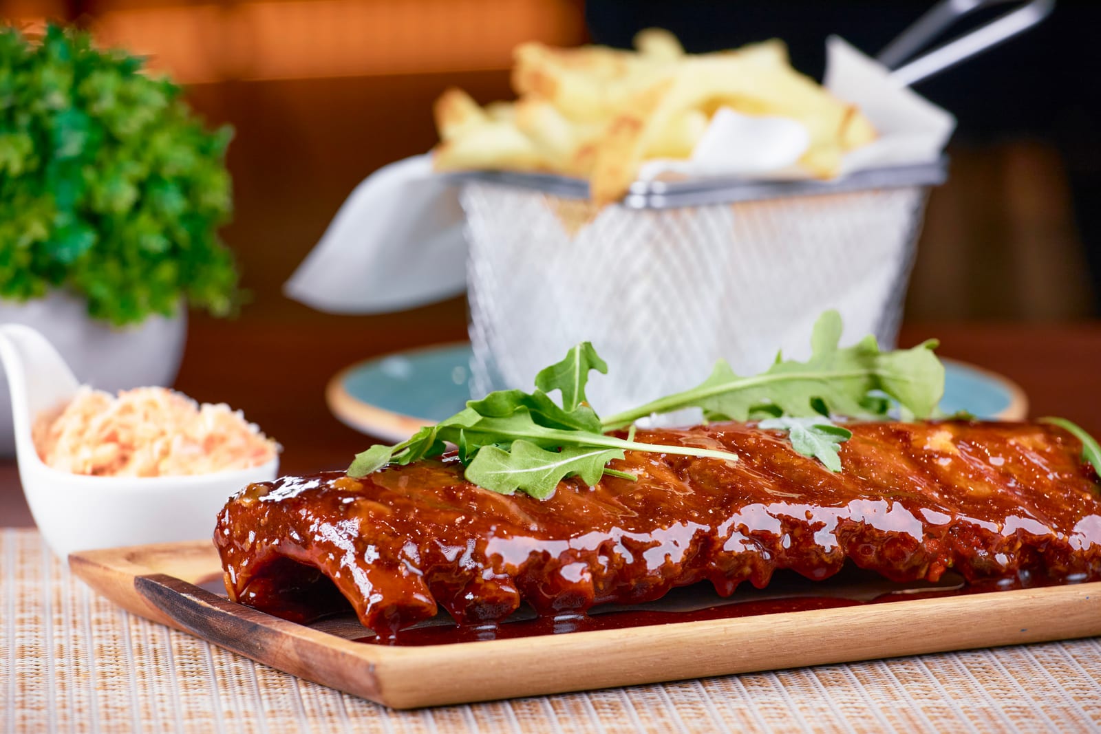 BBQ glazed ribs topped with rocket, served with coleslaw and a basket of chips