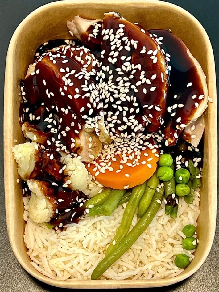 Meal-prep box of teriyaki chicken with sesame seeds, rice and vegetables