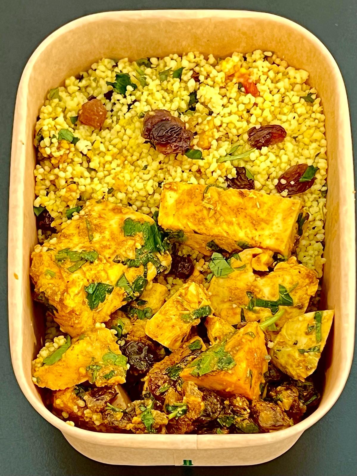Meal-prep box of chicken tagine with couscous, raisins and herbs